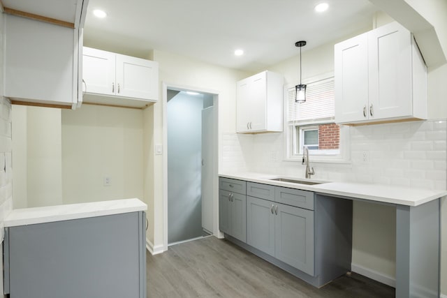 9250 Rosedale Blvd, Allen Park, MI 48101 - kitchen featuring gray cabinetry, light wood-type flooring, tasteful backsplash, decorative light fixtures, and light countertops