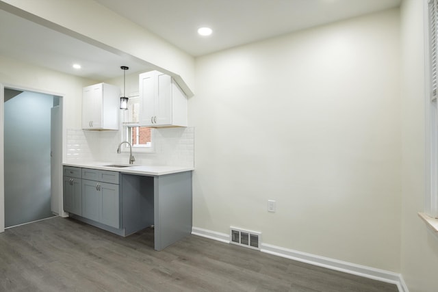 9250 Rosedale Blvd, Allen Park, MI 48101 - kitchen featuring light wood finished floors, backsplash, light countertops, gray cabinetry, and hanging light fixtures