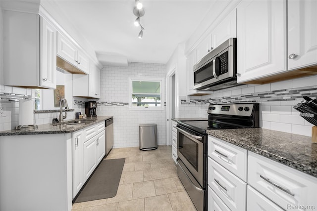 2195 Pembroke Rd, Birmingham, MI 48009 - kitchen featuring stainless steel appliances, white cabinets, and dark stone counters
