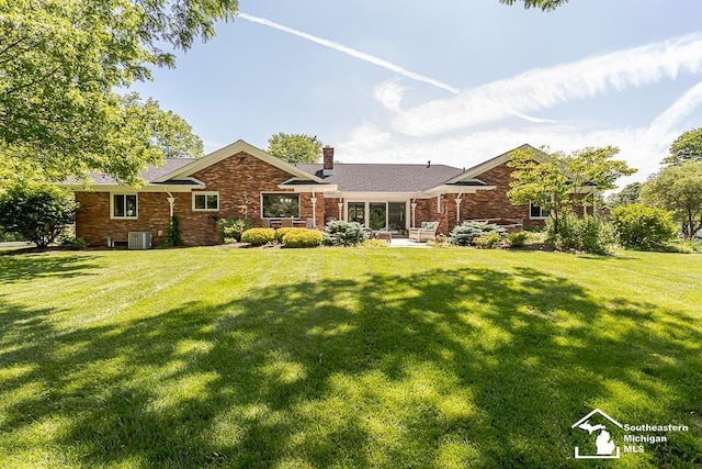 7007 Jackman Rd, Temperance, MI 48182 - view of front of home with a chimney, a front lawn, brick siding, and a patio area