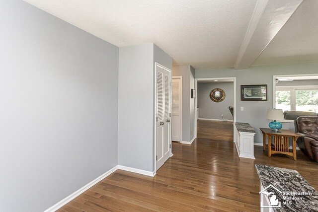 7007 Jackman Rd, Temperance, MI 48182 - hallway featuring wood finished floors, a textured ceiling, and beamed ceiling