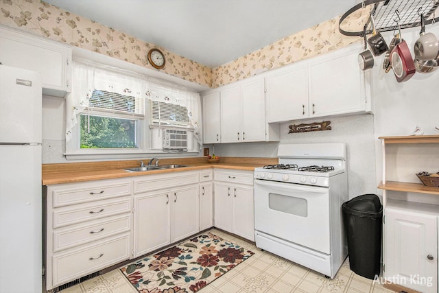 3156 Tuell St NW, Grand Rapids, MI 49504 - kitchen featuring white appliances, light countertops, white cabinets, light flooring, and wallpapered walls
