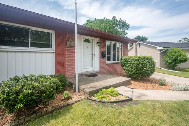 36067 Rolf St, Westland, MI 48186 - property entrance featuring brick siding, board and batten siding, and a yard