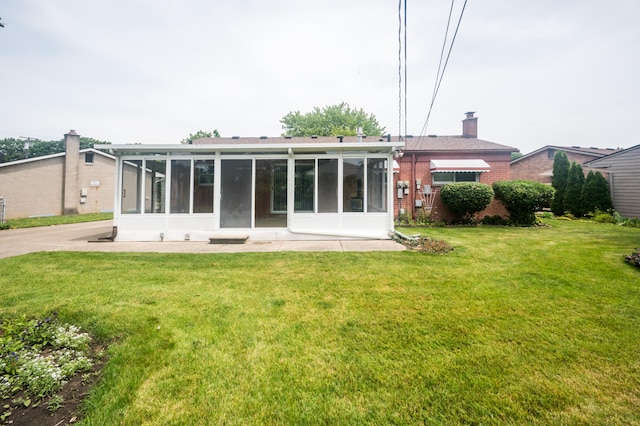 36067 Rolf St, Westland, MI 48186 - rear view of house featuring a sunroom, brick siding, a lawn, and a chimney