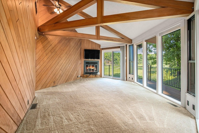 3536 Tamsin Ave, Kalamazoo, MI 49008 - unfurnished living room featuring wood walls, a glass covered fireplace, carpet floors, and ceiling fan