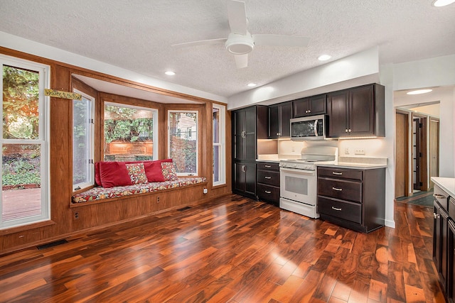 3536 Tamsin Ave, Kalamazoo, MI 49008 - kitchen with white stove, stainless steel microwave, a textured ceiling, light countertops, and dark wood-type flooring