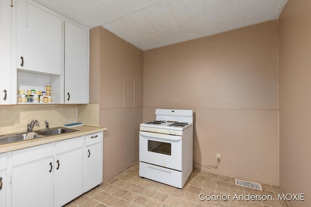 1523 Broadway Ave NW, Grand Rapids, MI 49504 - kitchen featuring gas range gas stove, light countertops, white cabinets, open shelves, and a wainscoted wall