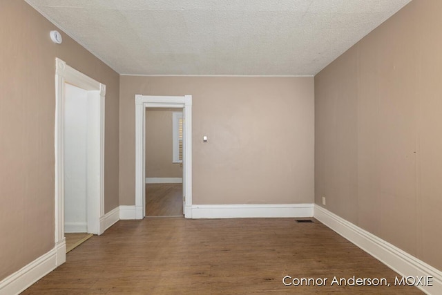 1523 Broadway Ave NW, Grand Rapids, MI 49504 - empty room with wood finished floors, a smoke detector, and a textured ceiling