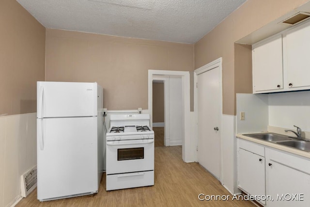 1523 Broadway Ave NW, Grand Rapids, MI 49504 - kitchen featuring white appliances, light wood-type flooring, white cabinets, light countertops, and a textured ceiling