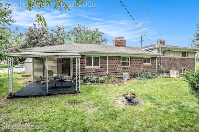 181 S Josephine Ave, Pontiac, MI 48341 - rear view of property with a fire pit, brick siding, and a lawn