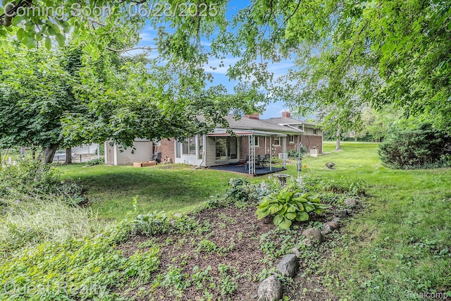 181 S Josephine Ave, Pontiac, MI 48341 - back of property with brick siding, a yard, a chimney, and a patio area