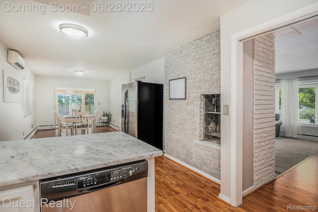 181 S Josephine Ave, Pontiac, MI 48341 - kitchen with stainless steel appliances, brick wall, wood finished floors, plenty of natural light, and a wall unit AC