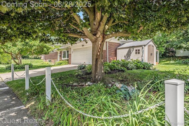 181 S Josephine Ave, Pontiac, MI 48341 - view of property hidden behind natural elements with a storage unit, a garage, brick siding, driveway, and a front lawn