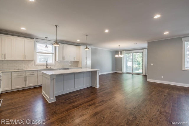2663 Griffith Ave, Berkley, MI 48072 - kitchen with ornamental molding, a center island, decorative backsplash, light countertops, and white cabinetry