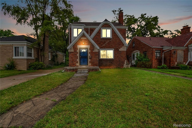 10825 E Outer Dr, Detroit, MI 48224 - tudor-style house featuring brick siding, a lawn, and a chimney