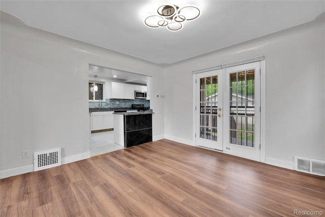 10825 E Outer Dr, Detroit, MI 48224 - kitchen with appliances with stainless steel finishes, dark countertops, white cabinets, and wood finished floors