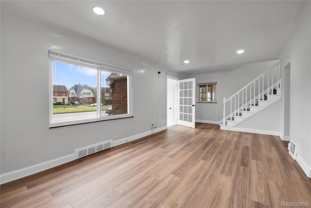 10825 E Outer Dr, Detroit, MI 48224 - unfurnished living room featuring stairway, wood finished floors, recessed lighting, and french doors