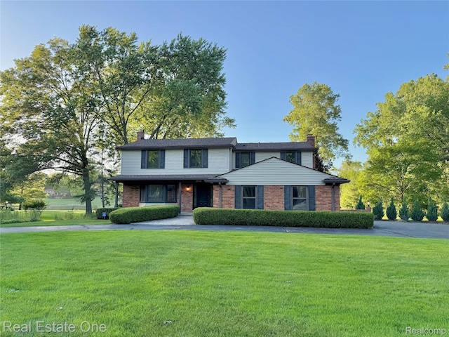 2546 Limerick Ln, Troy, MI 48098 - view of front facade with a chimney, a front yard, and brick siding