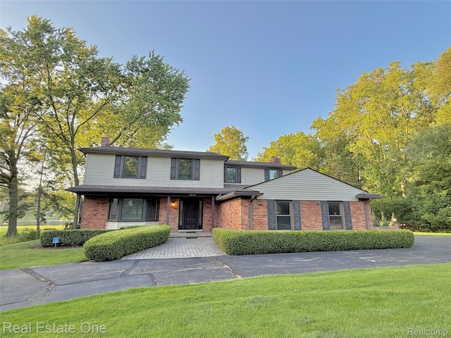 2546 Limerick Ln, Troy, MI 48098 - traditional-style home featuring a chimney, brick siding, and a front yard