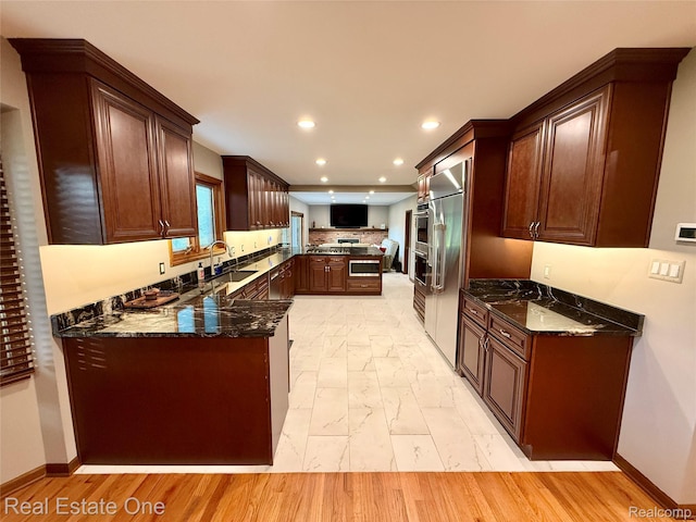 2546 Limerick Ln, Troy, MI 48098 - kitchen featuring a peninsula, recessed lighting, dark stone countertops, stainless steel appliances, and decorative backsplash