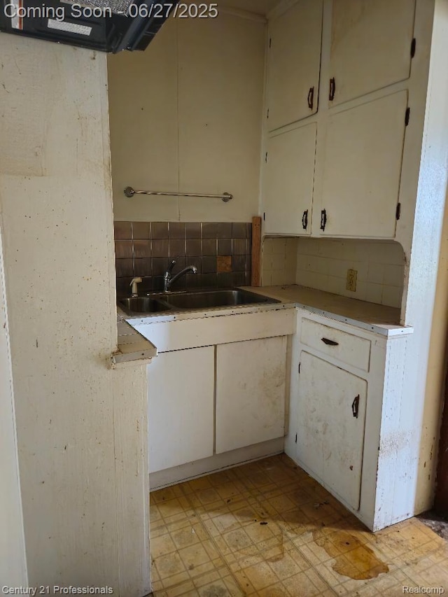 4428 Elizabeth St, Wayne, MI 48184 - kitchen with light flooring, backsplash, and white cabinetry