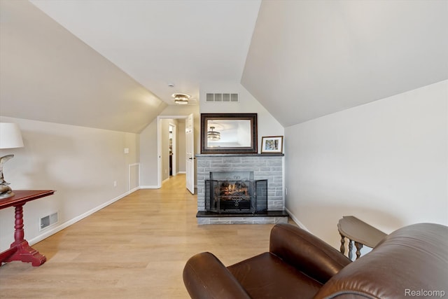6201 Academy Dr, Brighton, MI 48116 - living area with light wood-type flooring, vaulted ceiling, and a stone fireplace