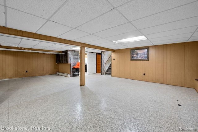 25560 Wexford Ave, Warren, MI 48091 - finished below grade area featuring a drop ceiling, stairs, wood walls, and a baseboard heating unit