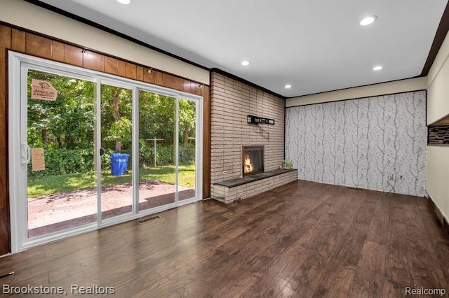 25560 Wexford Ave, Warren, MI 48091 - unfurnished living room with wood finished floors, a brick fireplace, and recessed lighting