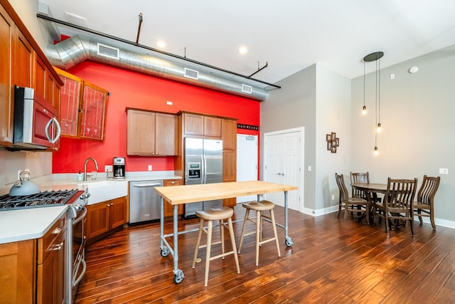 403 State St Unit 6, Saint Joseph, MI 49085 - kitchen featuring appliances with stainless steel finishes, light countertops, dark wood finished floors, high vaulted ceiling, and hanging light fixtures