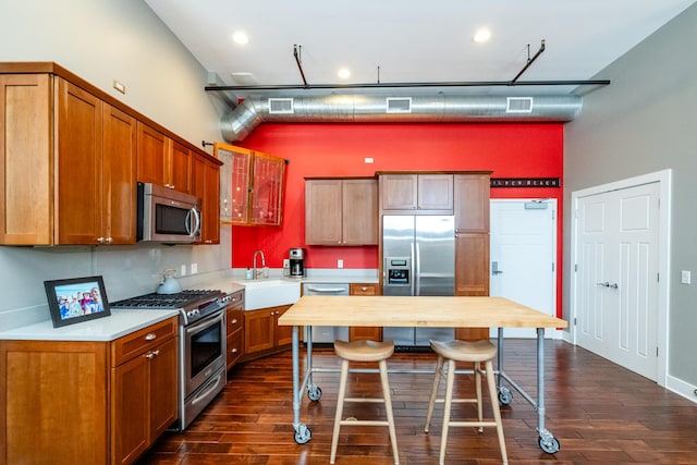 403 State St Unit 6, Saint Joseph, MI 49085 - kitchen with stainless steel appliances, a towering ceiling, dark wood-type flooring, a breakfast bar, and brown cabinetry