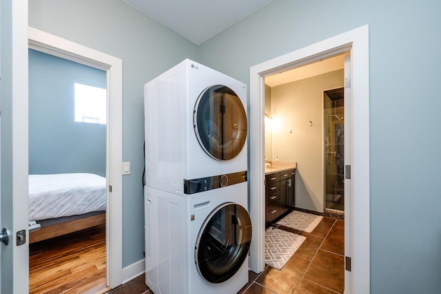 403 State St Unit 6, Saint Joseph, MI 49085 - washroom featuring stacked washer / drying machine and dark tile patterned flooring
