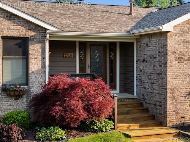 5131 Navajo Trl, Pinckney, MI 48169 - property entrance featuring a shingled roof and brick siding