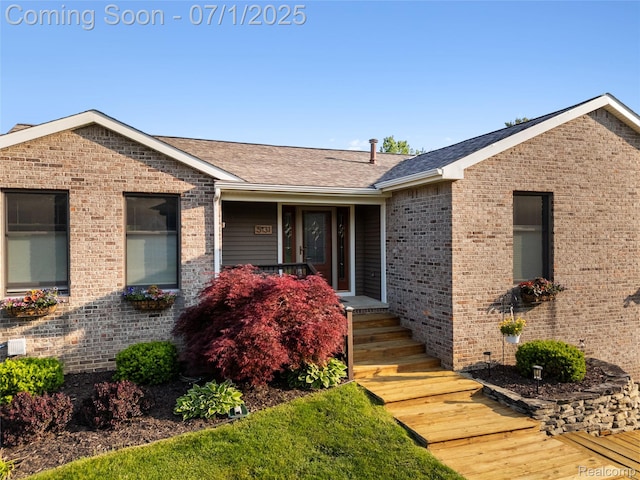 5131 Navajo Trl, Pinckney, MI 48169 - view of front facade featuring brick siding, a porch, and a shingled roof
