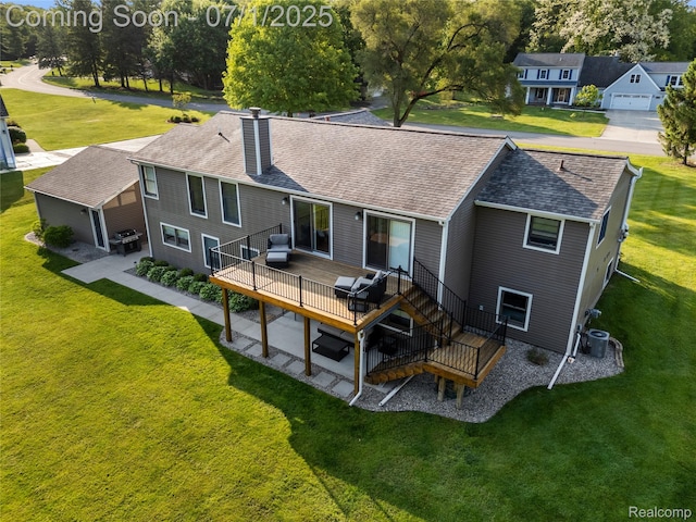 5131 Navajo Trl, Pinckney, MI 48169 - back of property featuring a chimney, a wooden deck, roof with shingles, and a yard