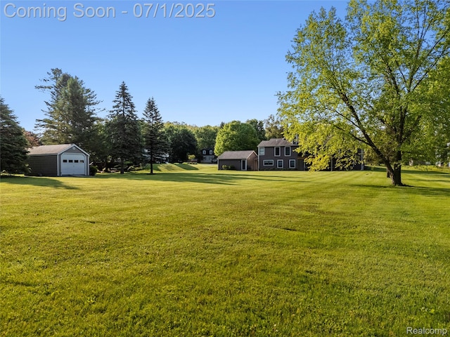 5131 Navajo Trl, Pinckney, MI 48169 - view of grassy yard with a garage, an outdoor structure, and view of wooded area