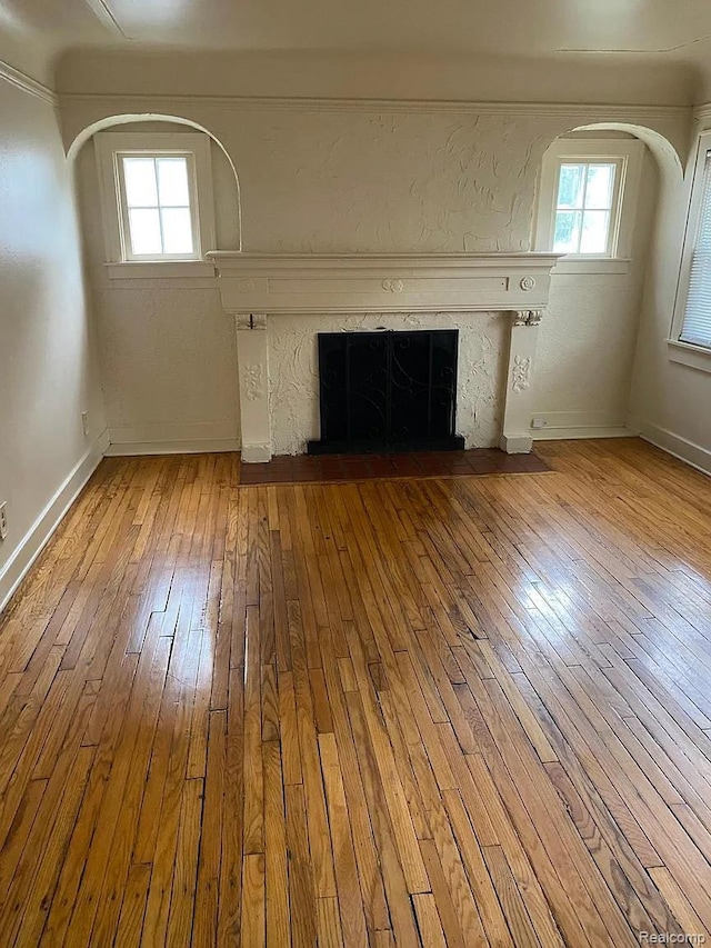 32 S Marshall St, Pontiac, MI 48342 - unfurnished living room with a premium fireplace, hardwood / wood-style floors, healthy amount of natural light, and arched walkways