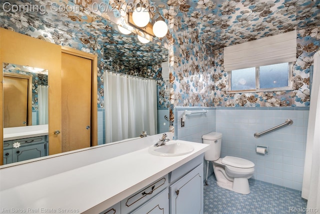 693 Anita Ave, Grosse Pointe Woods, MI 48236 - bathroom with wallpapered walls, wainscoting, vanity, tile walls, and tile patterned flooring