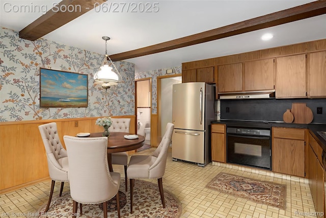 693 Anita Ave, Grosse Pointe Woods, MI 48236 - kitchen featuring freestanding refrigerator, black oven, wallpapered walls, under cabinet range hood, and beam ceiling