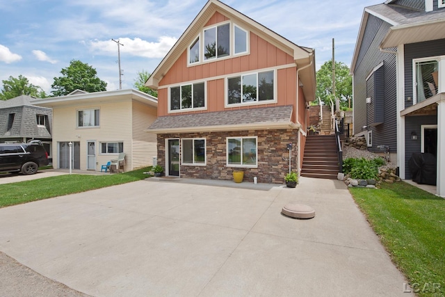 680 Breyman Hwy, Tipton, MI 49287 - view of front facade with board and batten siding, stairway, stone siding, and a front yard