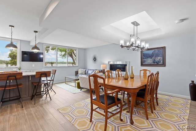 680 Breyman Hwy, Tipton, MI 49287 - dining space featuring a raised ceiling, a chandelier, and light wood finished floors
