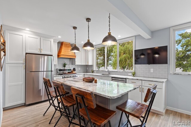 680 Breyman Hwy, Tipton, MI 49287 - kitchen with stainless steel appliances, premium range hood, backsplash, a breakfast bar, and recessed lighting