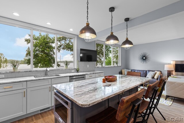 680 Breyman Hwy, Tipton, MI 49287 - kitchen with appliances with stainless steel finishes, open floor plan, tasteful backsplash, light wood finished floors, and white cabinets