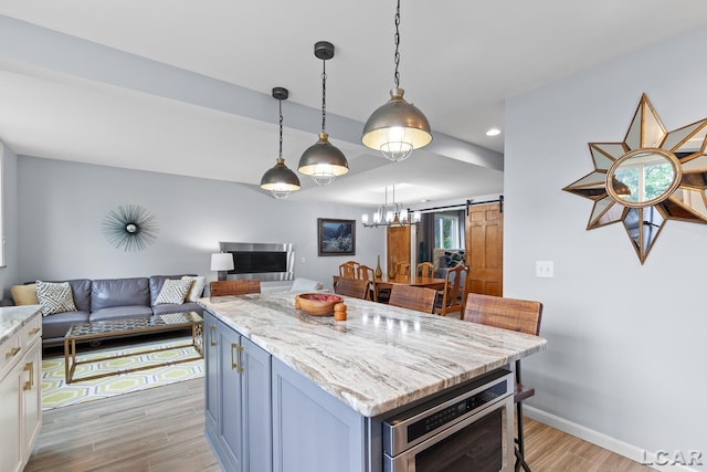 680 Breyman Hwy, Tipton, MI 49287 - kitchen featuring a barn door, open floor plan, light wood-type flooring, light stone countertops, and recessed lighting