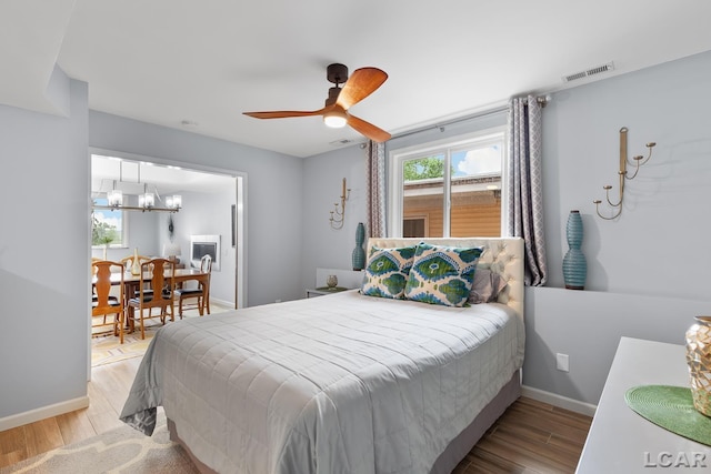 680 Breyman Hwy, Tipton, MI 49287 - bedroom with wood finished floors, a chandelier, and ceiling fan