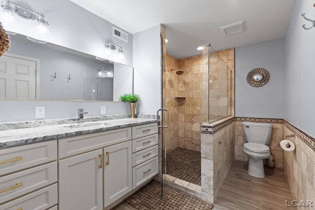 680 Breyman Hwy, Tipton, MI 49287 - bathroom featuring a stall shower, vanity, tile walls, and a wainscoted wall