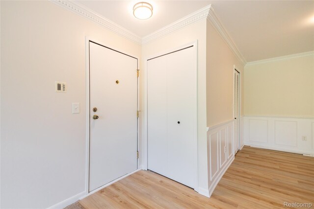 10228 Nancys Blvd Unit 33, Grosse Ile, MI 48138 - entryway featuring light wood-style floors, crown molding, a wainscoted wall, and a decorative wall