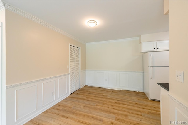 10228 Nancys Blvd Unit 33, Grosse Ile, MI 48138 - unfurnished dining area with crown molding, wainscoting, light wood-type flooring, and a decorative wall