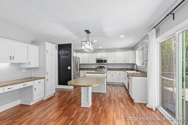 950 Whitetail Ct, Ionia, MI 48846 - kitchen featuring appliances with stainless steel finishes, dark wood finished floors, white cabinets, a kitchen island, and recessed lighting