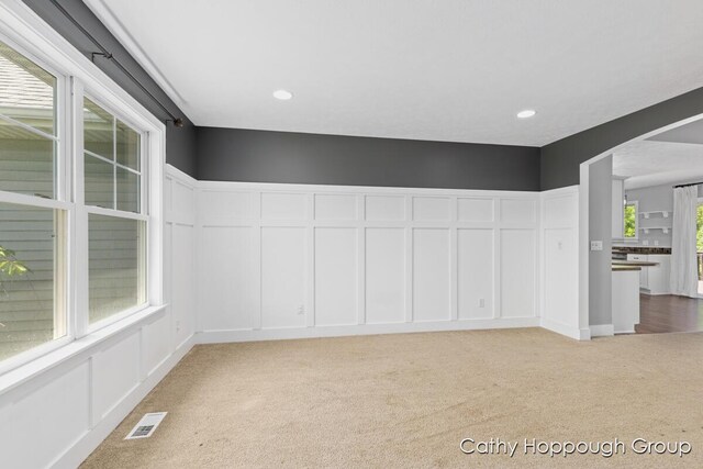 950 Whitetail Ct, Ionia, MI 48846 - carpeted spare room featuring arched walkways, a decorative wall, and recessed lighting