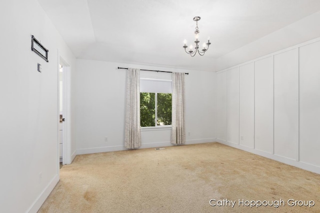 950 Whitetail Ct, Ionia, MI 48846 - empty room featuring a chandelier, carpet floors, and vaulted ceiling